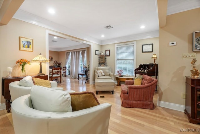 living room with crown molding, light hardwood / wood-style flooring, and a healthy amount of sunlight