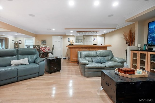 living room with ornamental molding and light hardwood / wood-style flooring