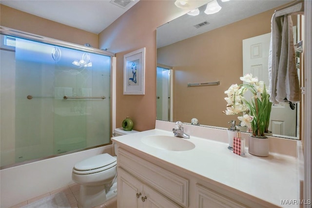 full bathroom featuring vanity, tile patterned flooring, shower / bath combination with glass door, and toilet