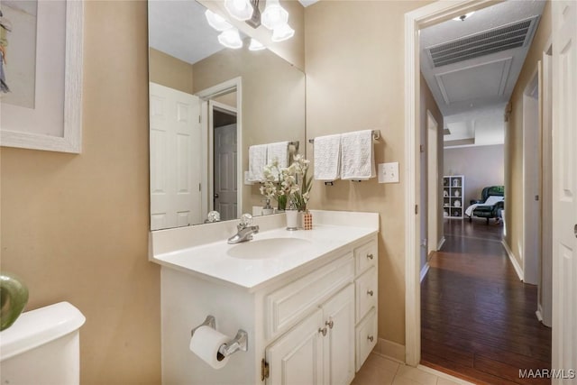 bathroom with tile patterned floors, vanity, toilet, and a chandelier