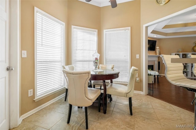 tiled dining room with crown molding and ceiling fan