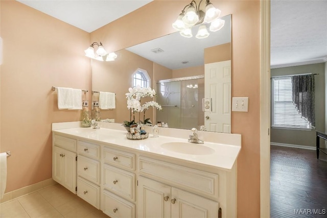 bathroom with an enclosed shower, vanity, and a chandelier