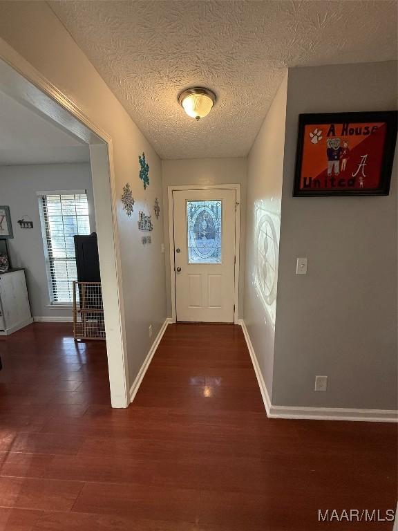 doorway to outside featuring dark hardwood / wood-style floors and a textured ceiling