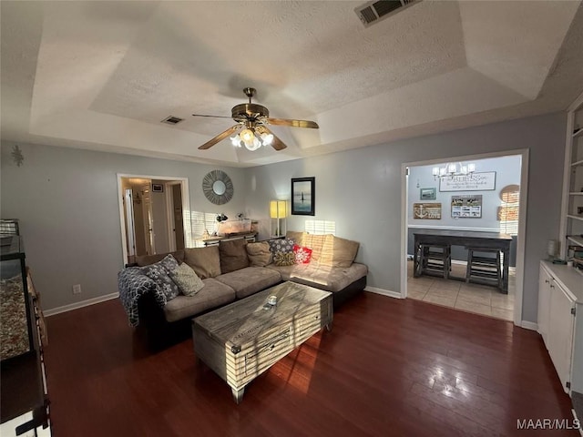 living room featuring hardwood / wood-style flooring, ceiling fan, a raised ceiling, and a textured ceiling