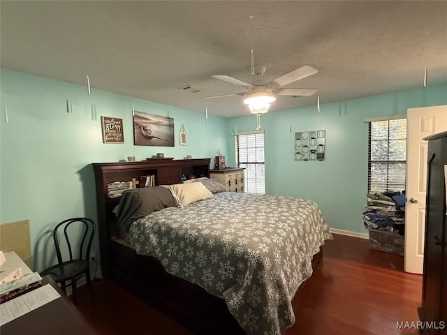 bedroom with dark hardwood / wood-style floors and ceiling fan