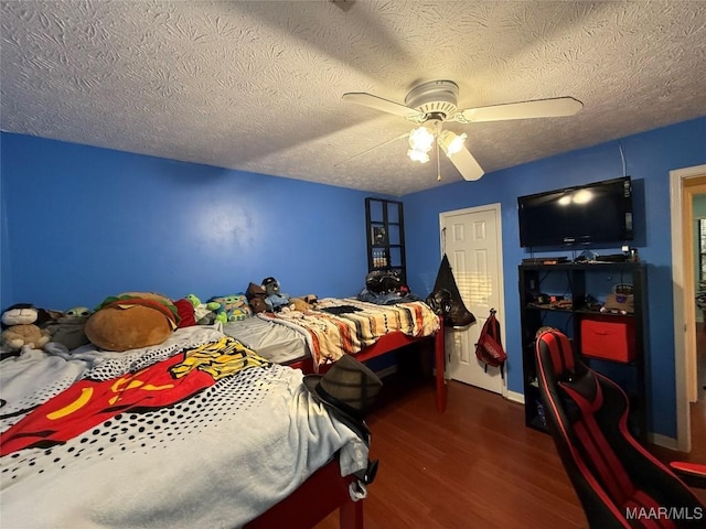 bedroom featuring ceiling fan, a textured ceiling, and dark hardwood / wood-style flooring