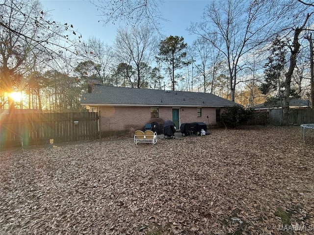 back house at dusk featuring a trampoline