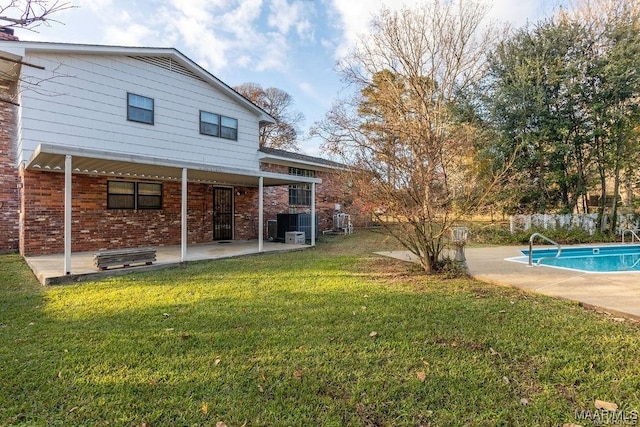 exterior space featuring a fenced in pool, a patio area, and a lawn