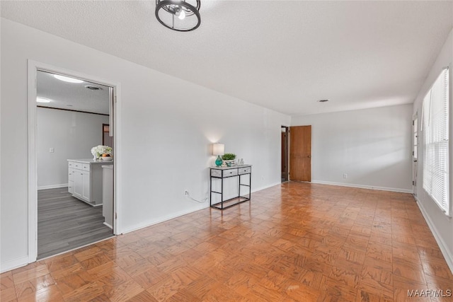 empty room with a textured ceiling and light parquet floors