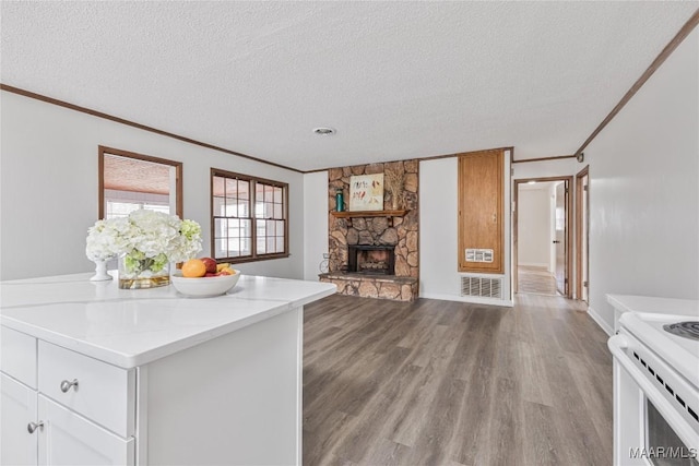 kitchen featuring white cabinetry, crown molding, light hardwood / wood-style floors, and a textured ceiling