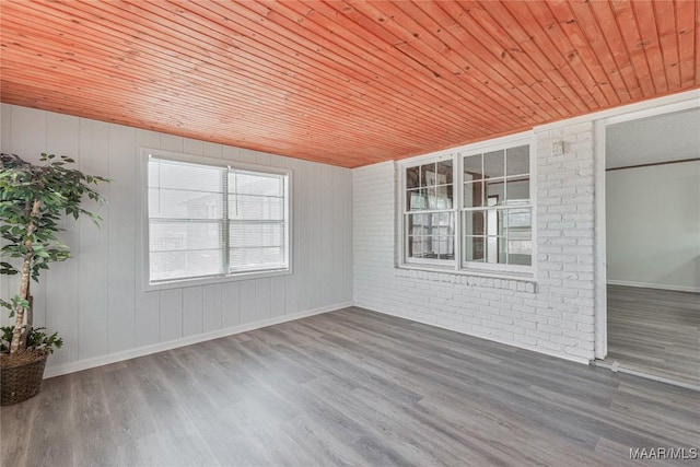 unfurnished room featuring wood ceiling, brick wall, and wood-type flooring