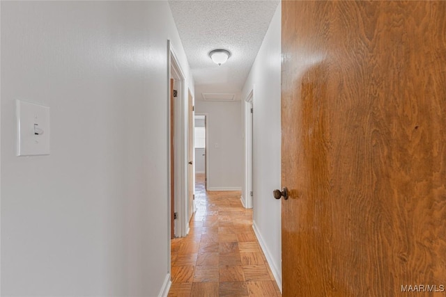 hall featuring light parquet flooring and a textured ceiling