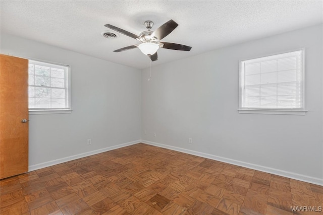 unfurnished room with ceiling fan, parquet flooring, and a textured ceiling