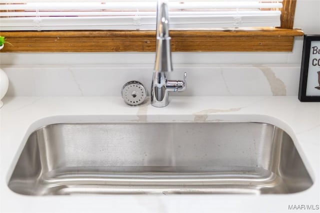 interior details featuring light stone countertops and sink