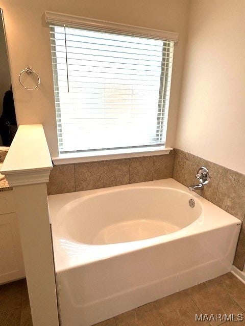 bathroom featuring tile patterned floors, vanity, and a tub