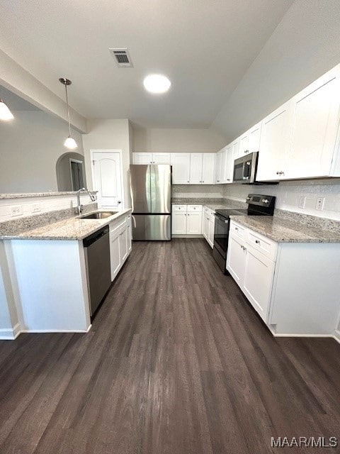 kitchen featuring sink, white cabinetry, light stone counters, hanging light fixtures, and appliances with stainless steel finishes