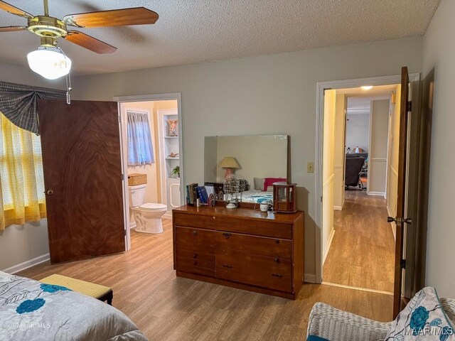 bedroom featuring connected bathroom, a textured ceiling, and light hardwood / wood-style floors