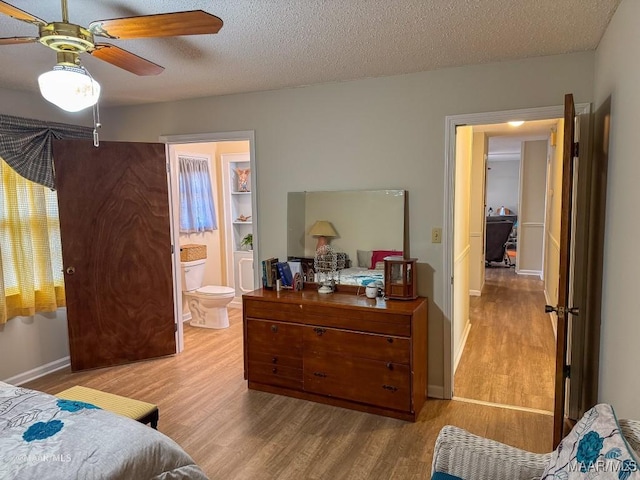 bedroom with light hardwood / wood-style flooring, a textured ceiling, and ensuite bathroom