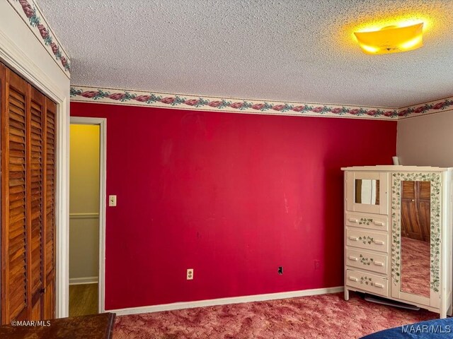 unfurnished bedroom featuring a closet, a textured ceiling, and carpet