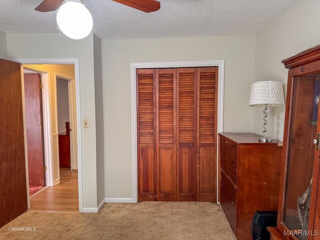 interior space featuring ceiling fan, a closet, and a textured ceiling