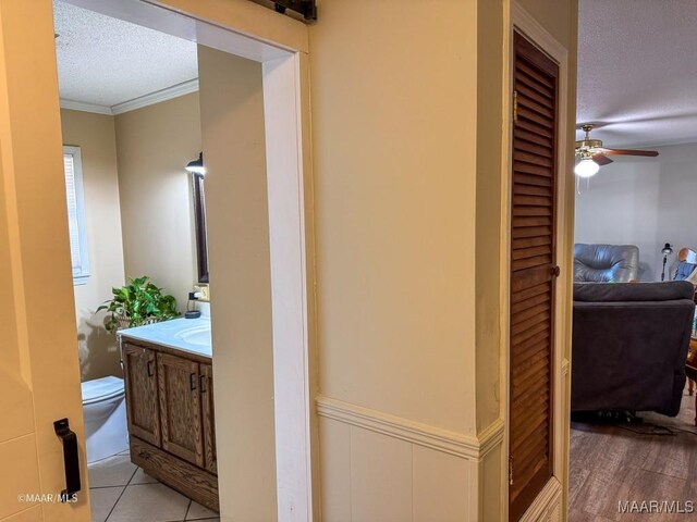 bathroom featuring crown molding, ceiling fan, vanity, a textured ceiling, and toilet