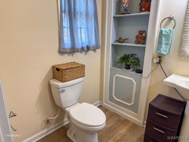 bathroom featuring hardwood / wood-style flooring and toilet