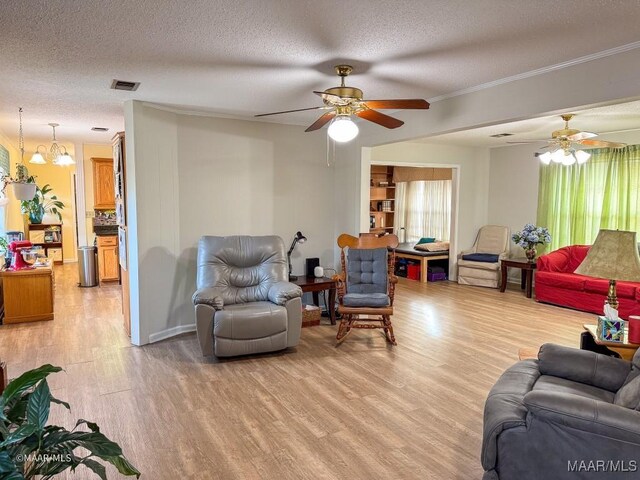 living room with crown molding, ceiling fan with notable chandelier, light hardwood / wood-style floors, and a textured ceiling