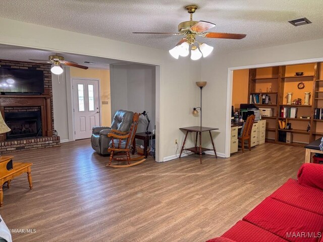 living room featuring hardwood / wood-style flooring, a fireplace, and a textured ceiling