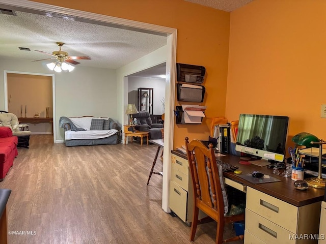 office featuring ceiling fan, hardwood / wood-style floors, and a textured ceiling