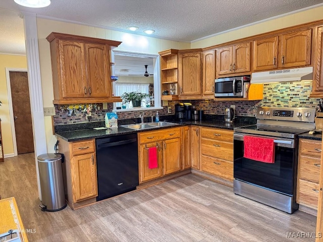 kitchen featuring sink, a textured ceiling, light wood-type flooring, ornamental molding, and appliances with stainless steel finishes