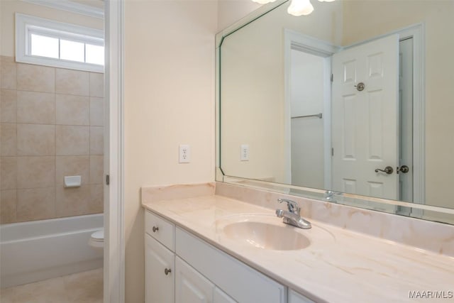 full bathroom with tile patterned flooring, vanity, tiled shower / bath combo, and toilet