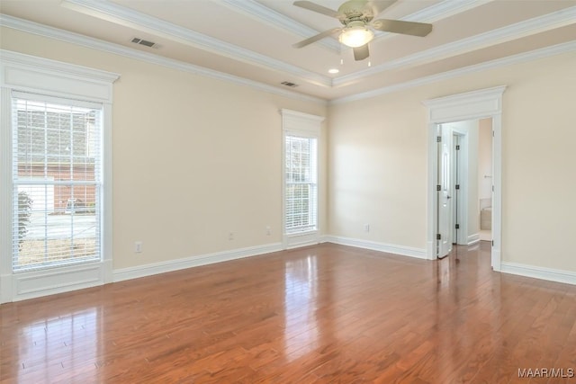 spare room featuring crown molding, a tray ceiling, and wood-type flooring