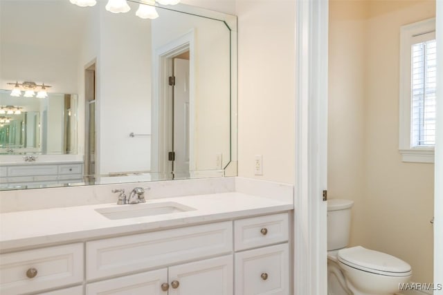 bathroom with vanity, plenty of natural light, and toilet