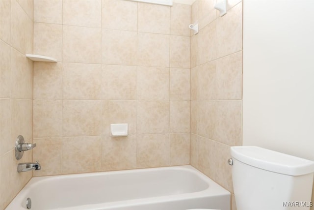 bathroom with tiled shower / bath combo and toilet