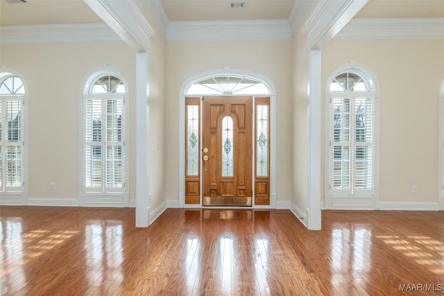 entrance foyer featuring ornamental molding and light hardwood / wood-style floors