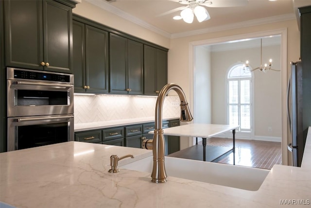 kitchen with light stone counters, ornamental molding, and stainless steel appliances