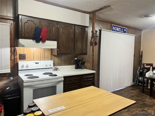 kitchen featuring white electric range, wood walls, dark hardwood / wood-style flooring, dark brown cabinets, and a textured ceiling