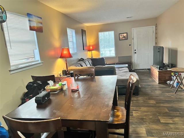 dining room featuring dark hardwood / wood-style floors and a textured ceiling