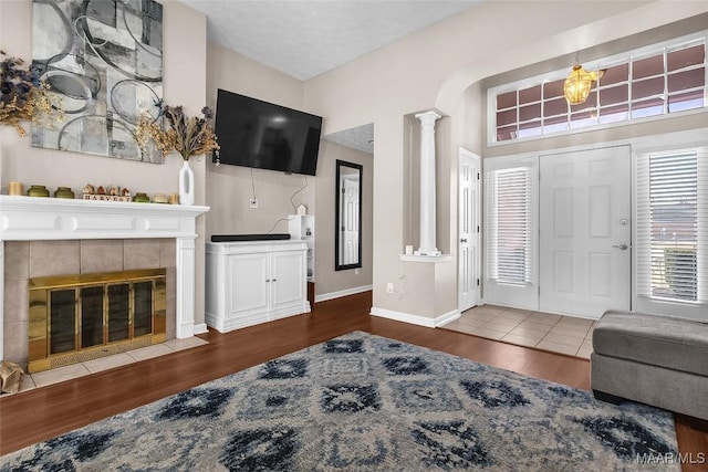 entryway featuring dark hardwood / wood-style flooring, a fireplace, and ornate columns