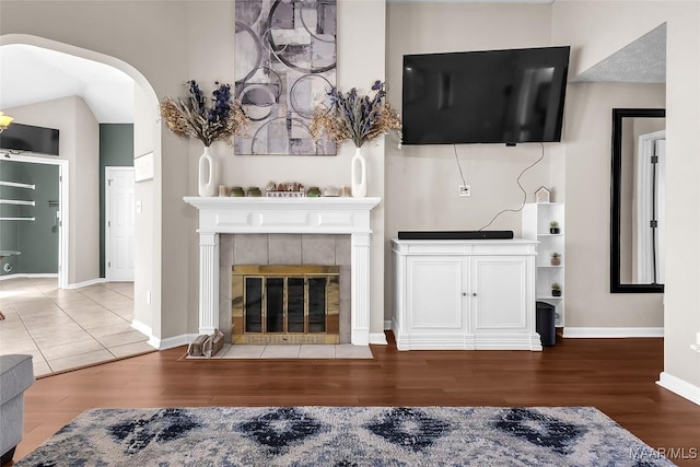 living room with hardwood / wood-style flooring and a tile fireplace