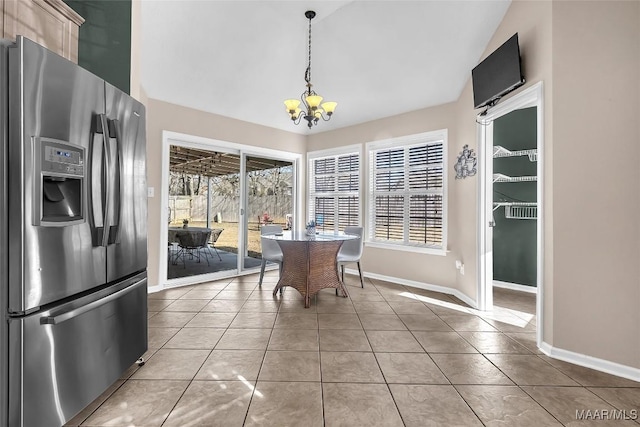 unfurnished dining area featuring an inviting chandelier, light tile patterned floors, and lofted ceiling