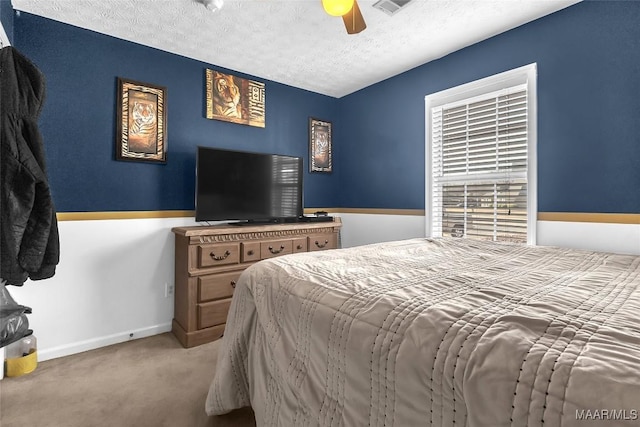 bedroom featuring ceiling fan, carpet, and a textured ceiling