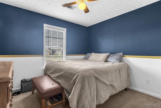 bedroom featuring light carpet, ceiling fan, and a textured ceiling