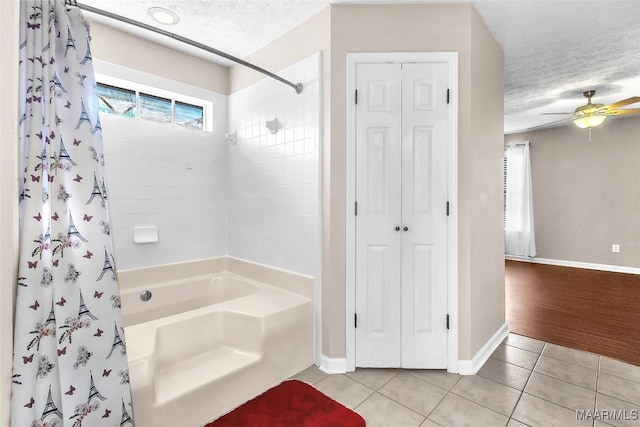 bathroom with tile patterned flooring, ceiling fan, shower / bathtub combination with curtain, and a textured ceiling