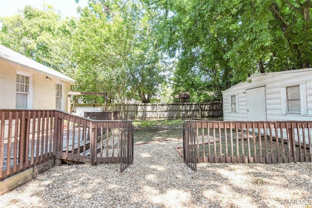 view of yard with a wooden deck and a storage unit