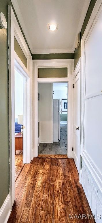 hallway featuring wood-type flooring and crown molding