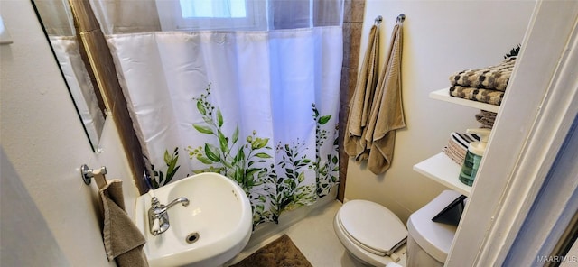 bathroom with walk in shower, sink, and toilet