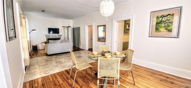 dining area featuring ornamental molding and hardwood / wood-style floors