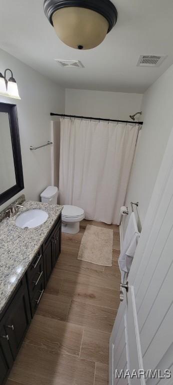 bathroom featuring a shower with shower curtain, vanity, toilet, and hardwood / wood-style floors