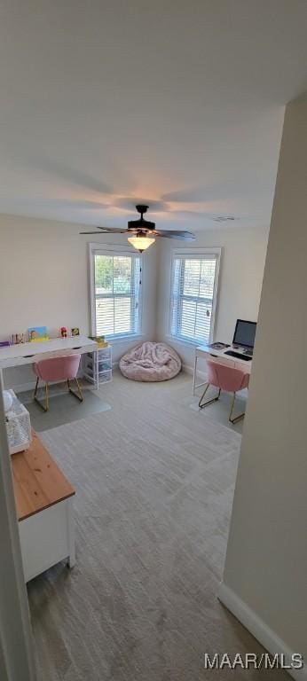 interior space with ceiling fan and carpet flooring